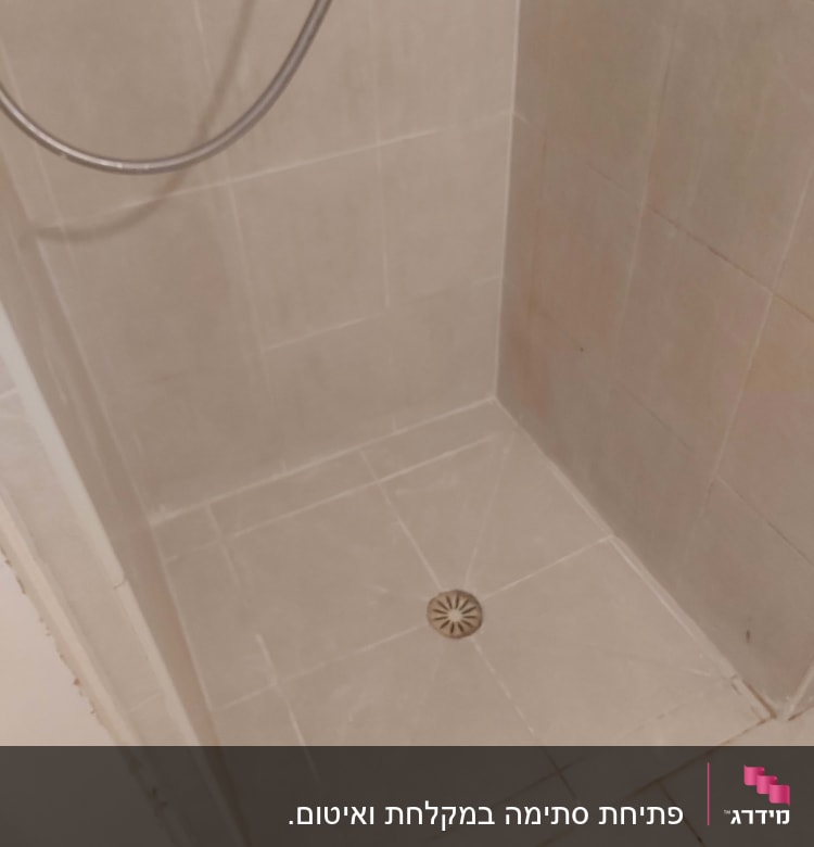 מקלחת עם ראש מקלחת וניקוז ברצפה